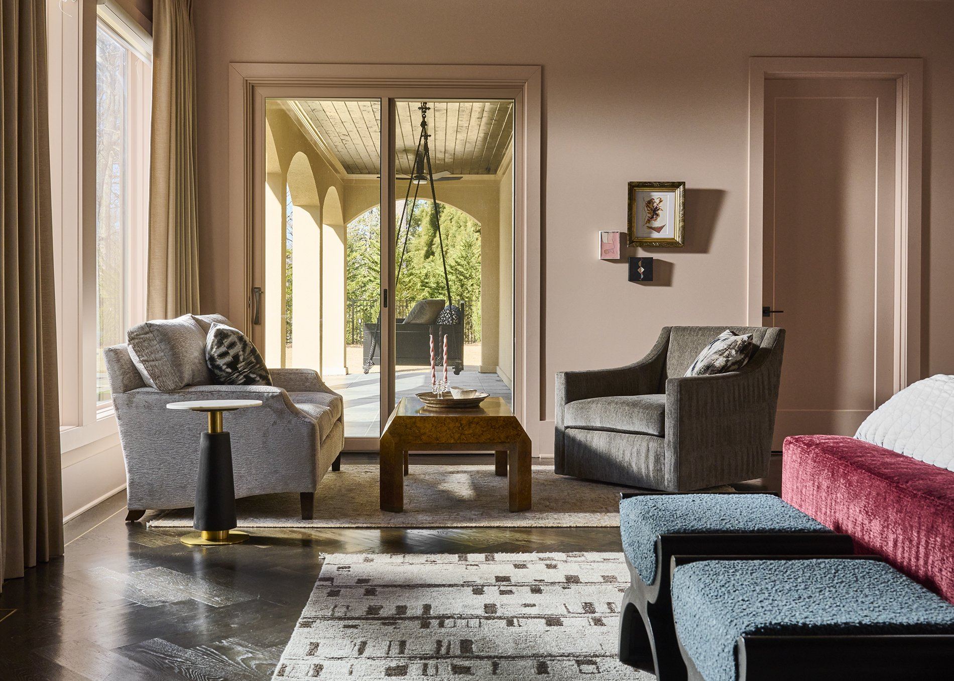 Primary suite sitting area with velvet upholstery and arched windows